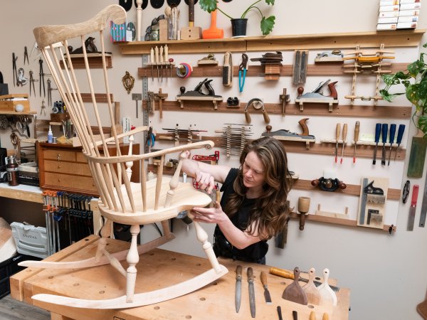 wood artist working on a rocking chair in a studio