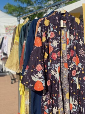 Series of colorful kimonos hanging on a rack outdoors