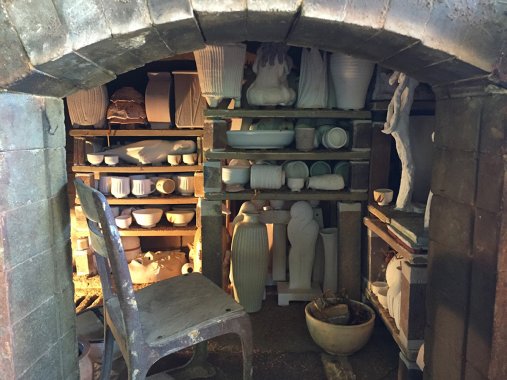inside of a kiln with shelves of unfired ceramic wares
