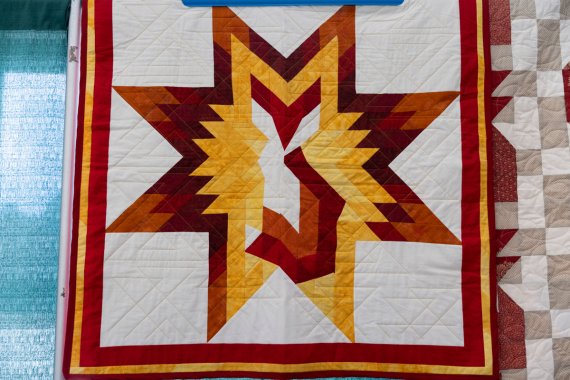 handmade orange red gold and white quilt with image of a fox and a start
