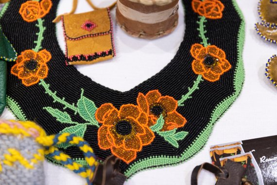 beadwork garment depicting flowers and leaves over black background