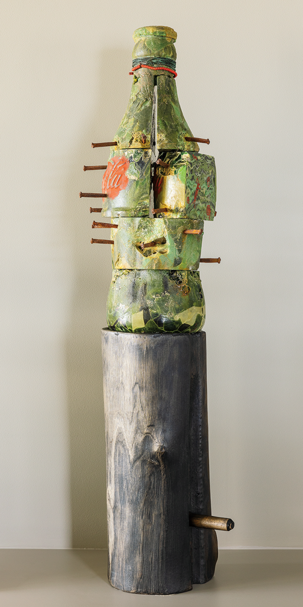Clifford Rainey, Fetish, 1990, recycled coke bottles cast in the lost wax method, painted, mold-formed inscription of North American Indian symbols from Arizona, iron nails, glass beads, oil paint, beechwood base, 39.5 x 10 x 9.5 in. Photo by Alanna Hale.