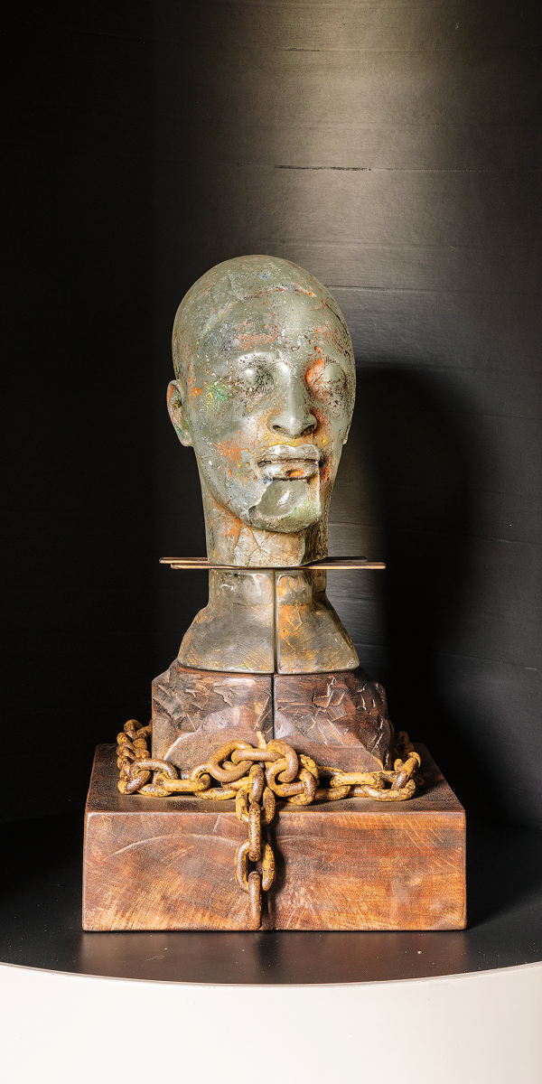 Clifford Rainey, Freedom of Conscience, 1989, glass cast in the lost wax method, cut and acid-etched, oil paint, dividers of wooden rulers, carved wood mount and stand, patinated chain and nails, 23.5 x 13 x 13.25 in. Photo by Alanna Hale.