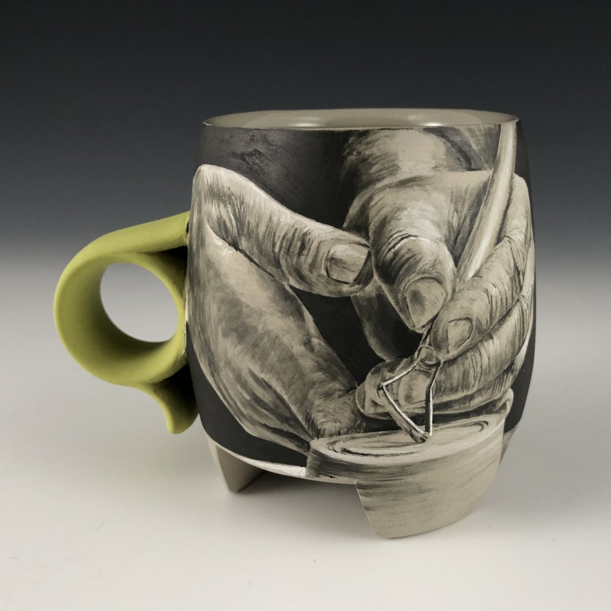Hand-painted porcelain mug with hands doing pottery.