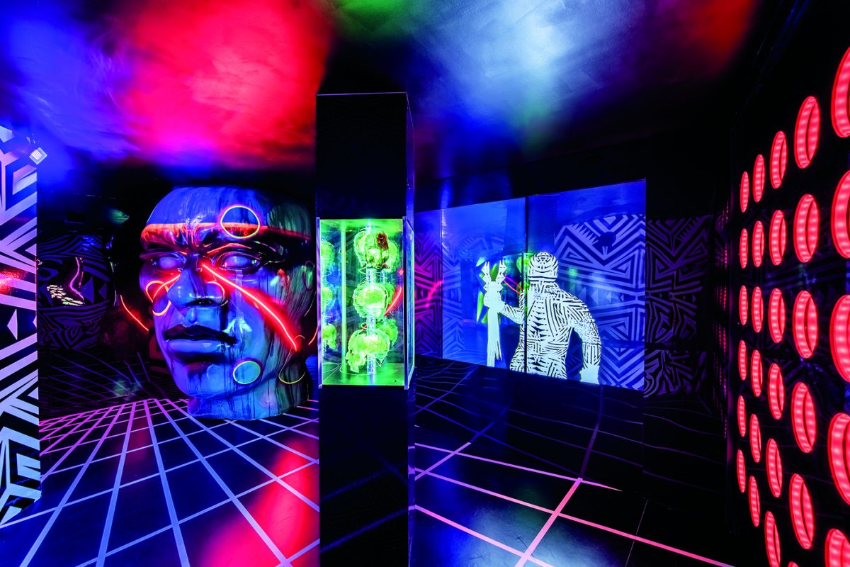 An art installation filled with bright neon colors and warrior images.