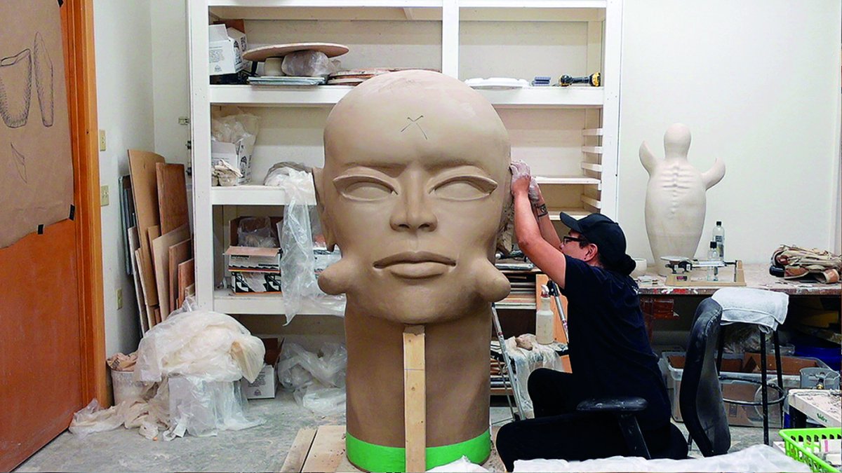 Artist works on large-scale bust.
