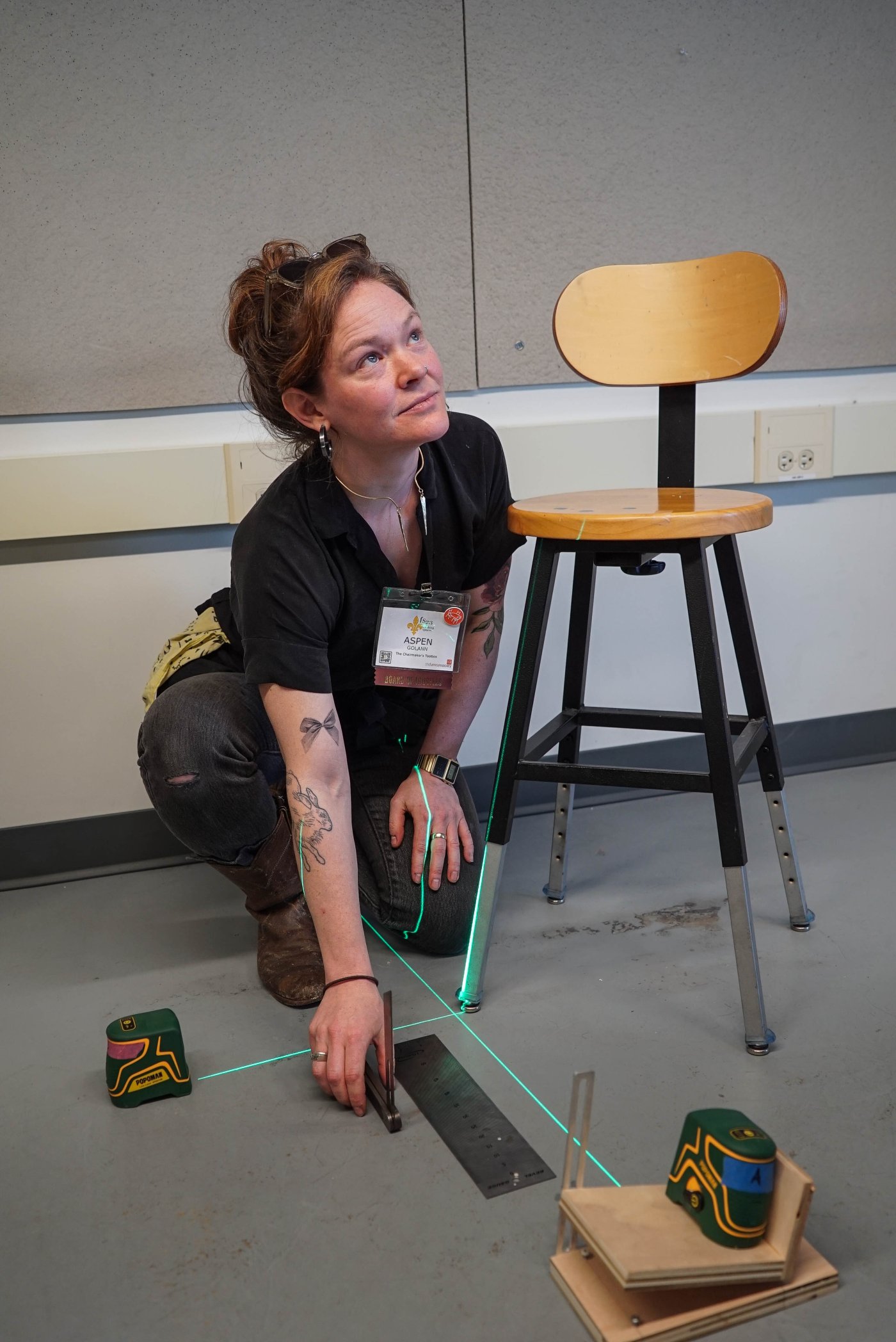 Aspen Golann demonstrates compound angle drilling techniques using tools on the floor at the conference.