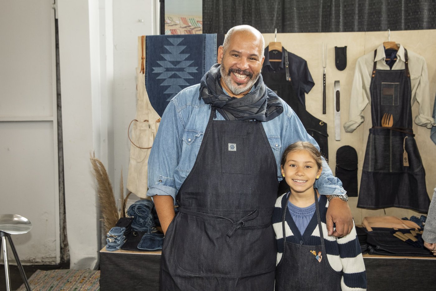 Artist Ulrich Conrad Simpson stands with his daughter in their durable denim aprons.