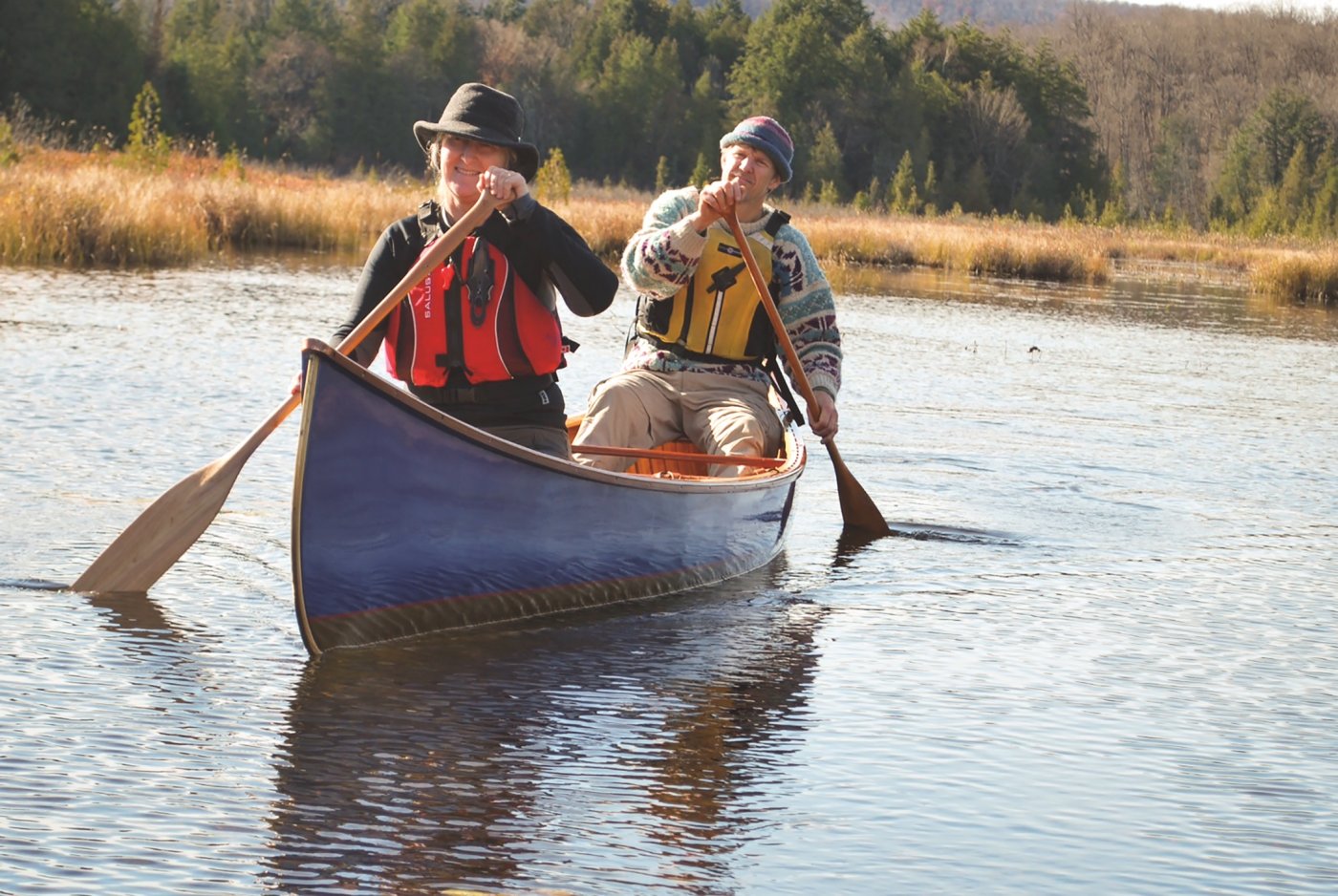 Two people paddling a canoe on open water.