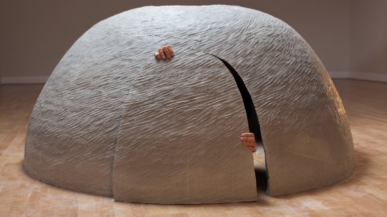 dome shaped ceramic shelter with hands prying open the door from the inside