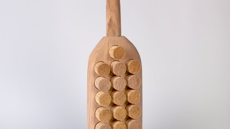 wooden sculpture reminscent of a paddle or brush