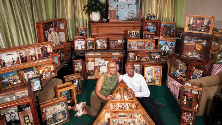 Two people centered amongst multiple dioramas. 