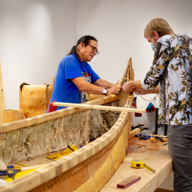 Wayne Valliere, a teacher with the Lac du Flambeau Band of Lake Superior Chippewa Indians, leads the construction of a birchbark canoe. Photo courtesy of Northwestern University.