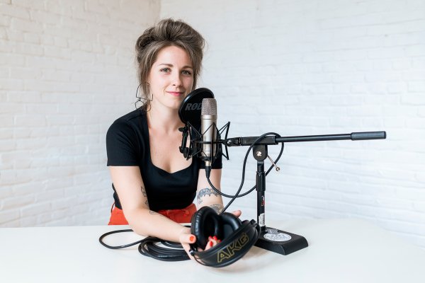 portrait of podcast host sarah rachel brown in recording studio with mic and headphones