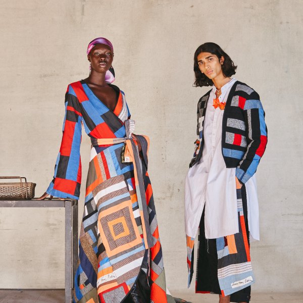 two models wearing garments made from colorful patchwork quilt with orange black red and earth tones