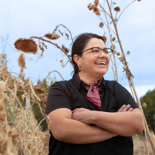 portrait of artist teri greeves posing in field with dried grasses and sunflowers