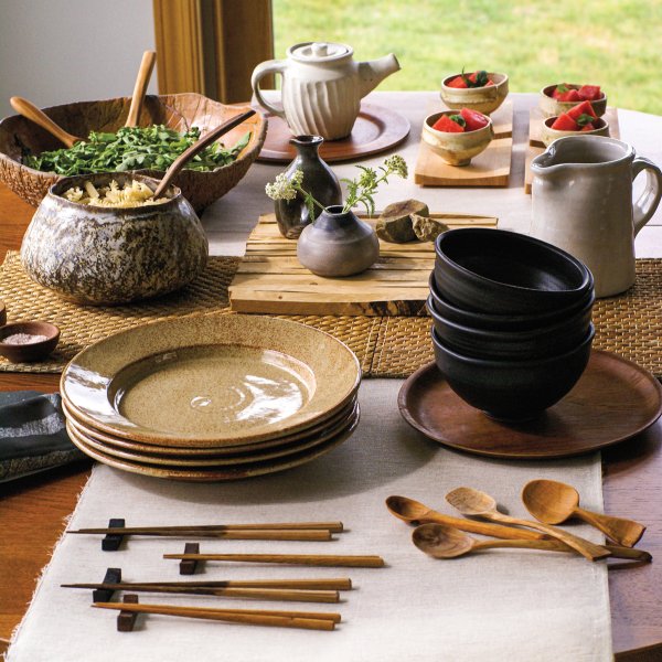 dining table with assortment of handmade dishes and utensils some with food