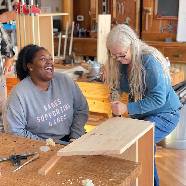 Lost Art Press Editor Megan Fitzpatrick demonstrates a smooth plane to Whitney Miller, a student and author of Henry Boyd’s Freedom Bed, in a Dutch tool chest class.