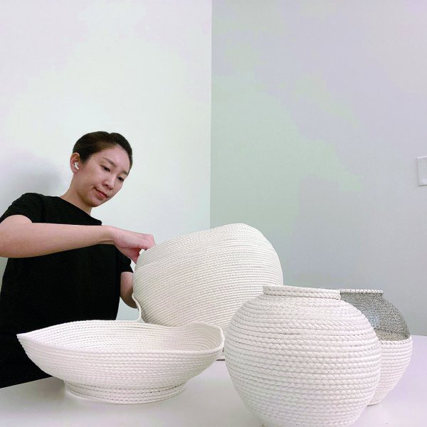 Artist Hyunsoo Alice Kim working on a woven moonjar.