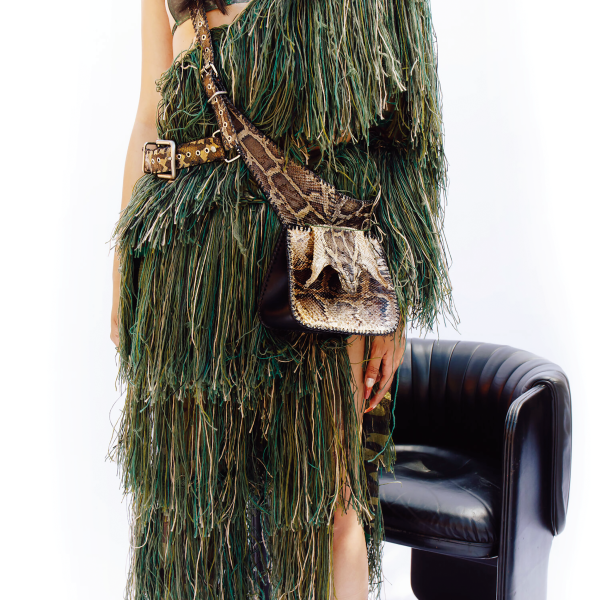 Model wears a deconstructed Ghillie suit and python cross-body skeleton vest with detachable ammo pouch and snake head detail.