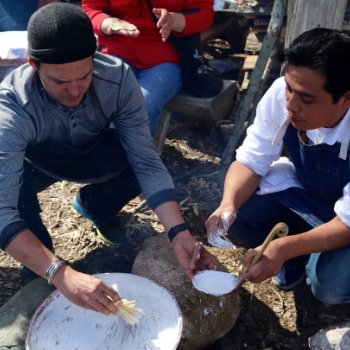 Neftali Duran instructing someone on cooking with a clay comal