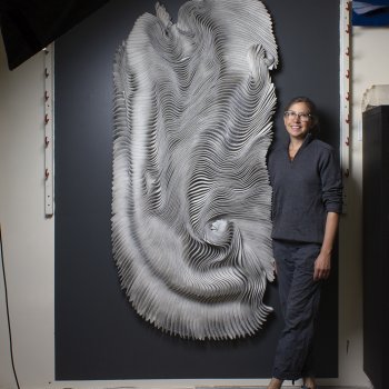 artist posing with hand felted sculptural wall art