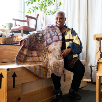 textile artist karen hampton holding weaving in studio