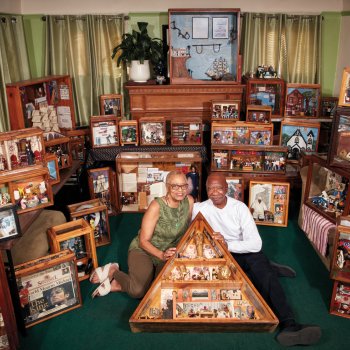 Two people centered amongst multiple dioramas. 