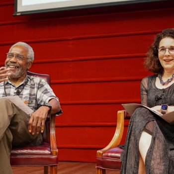 Michael Puryear and Rosanne Somerson sitting on a stage in 2 chairs during a keynote presentation at the Furniture Society conference in New Orleans. 