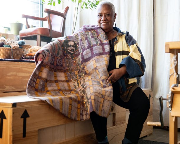 textile artist karen hampton holding weaving in studio