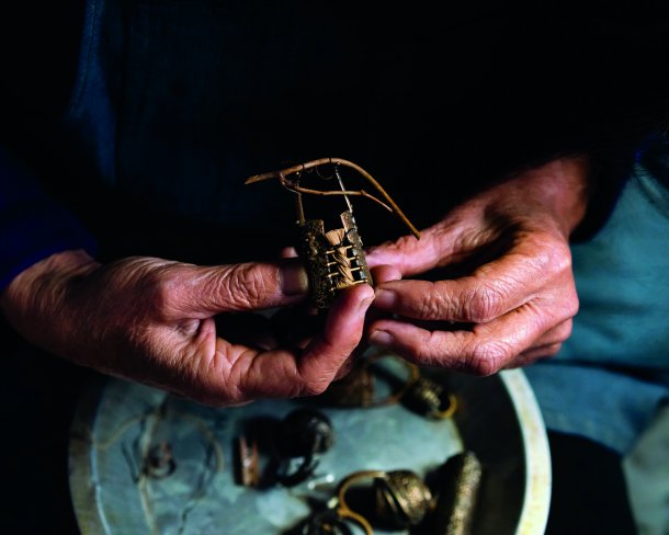 Suzye Ogawa holds a miniature vessel from bronze and natural materials.
