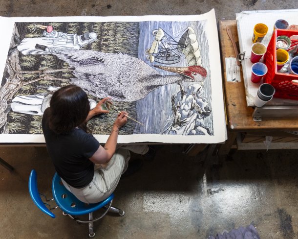 Pippin Frisbie-Calder applies watercolor to her 2017 woodcut Contemporary Heroes, which references Operation Migration and supports conservation groups, 69 x 39 in. Photo by Cedric Angeles.